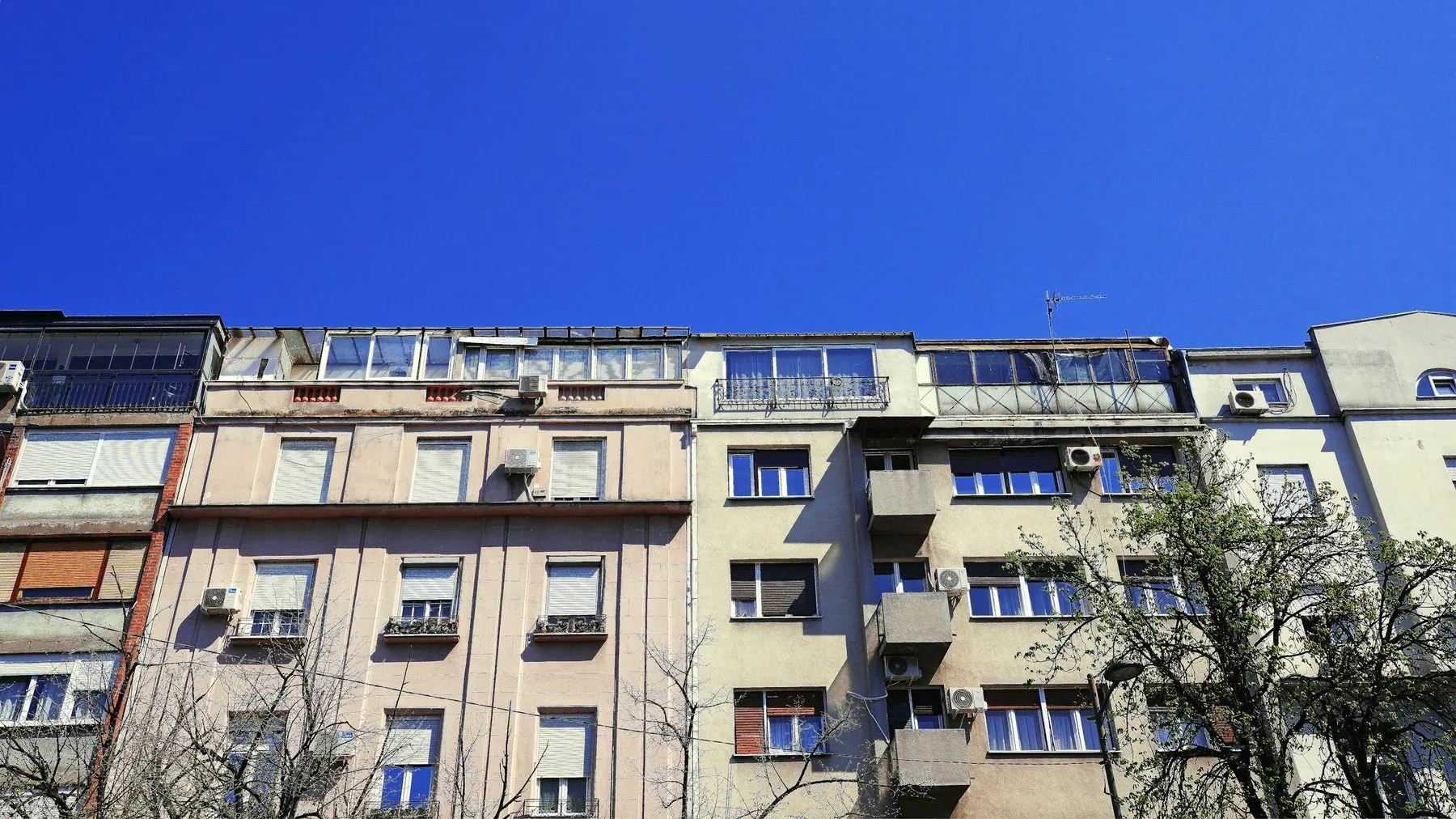 Old apartment buildings under a clear blue sky