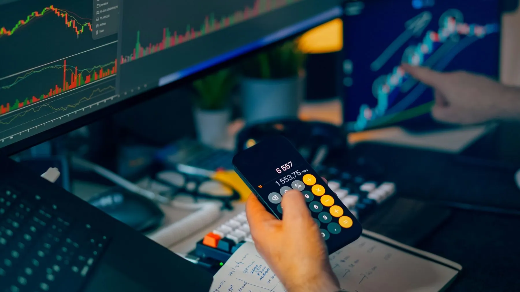 Financial trading workstation stock crypto investment analysis. Closeup hand holding smartphone calculator desk monitors