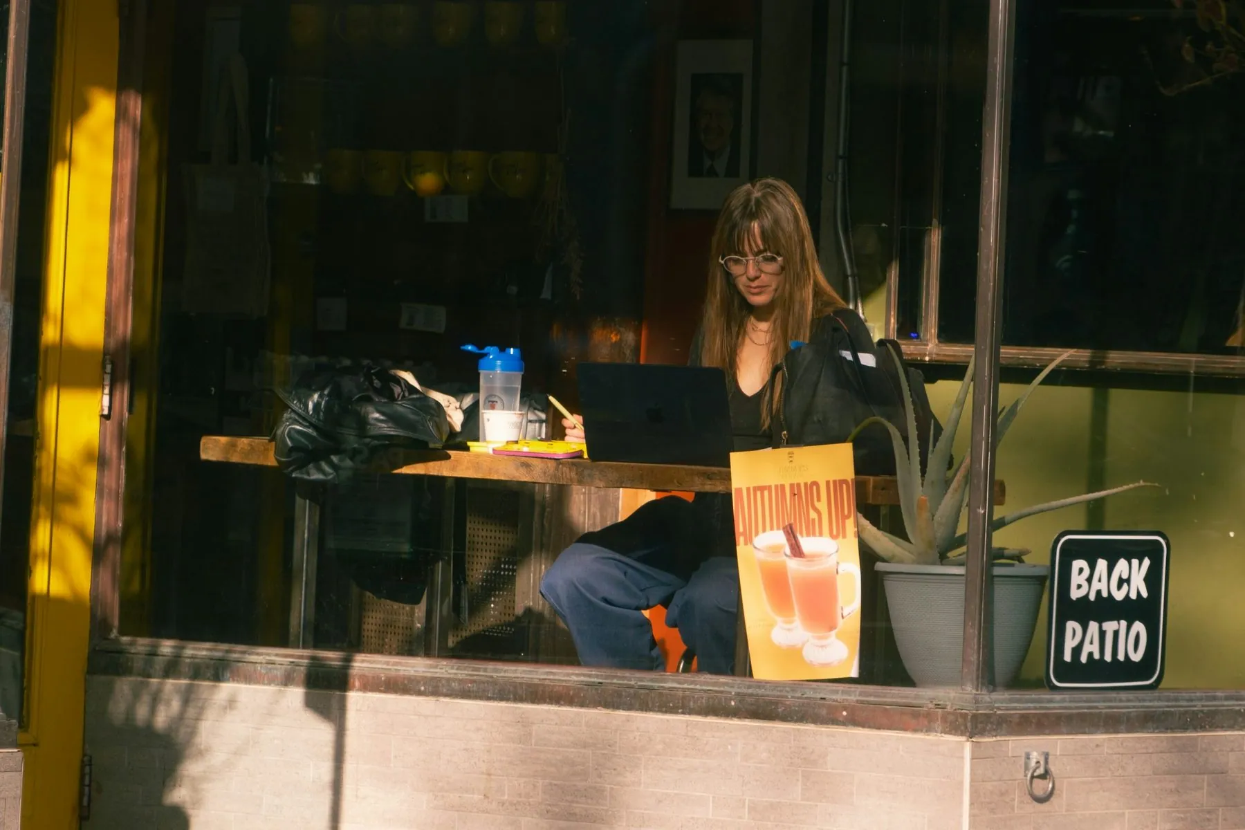 Woman working on laptop at outdoor cafe table